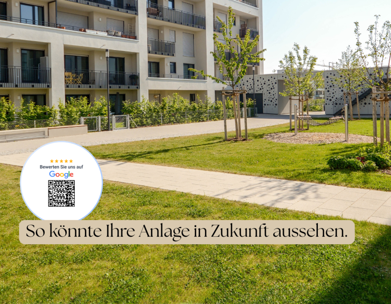 Grüne Rasenfläche mit Bäumen und modernen Wohngebäuden im Hintergrund.