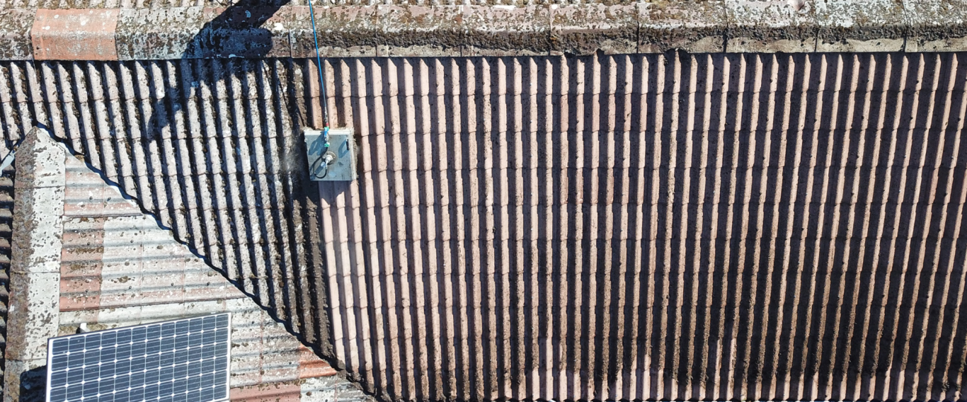 Dachreiniger bei der Arbeit auf einem Betonziegeldach